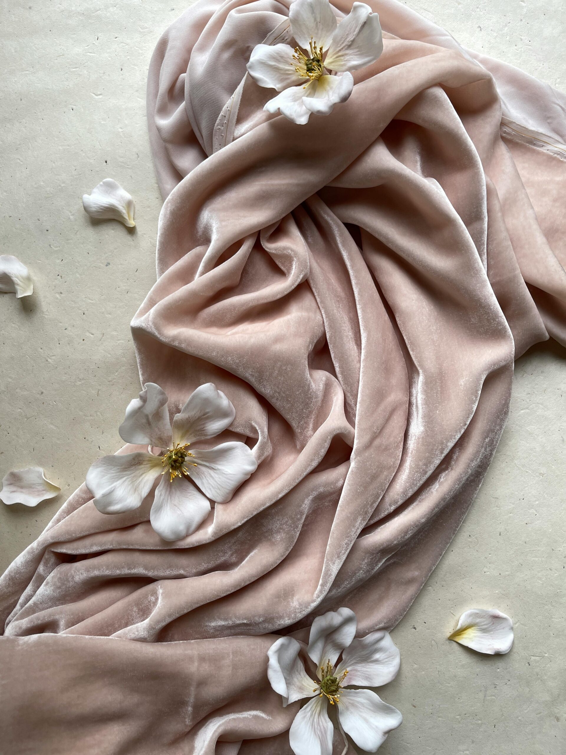 What Is Fashion Psychology, Really? (And Why It’s More Than What You Wear) 1 A draped pink velvet fabric with white flowers, symbolizing the emotional and sensory connections within fashion psychology.