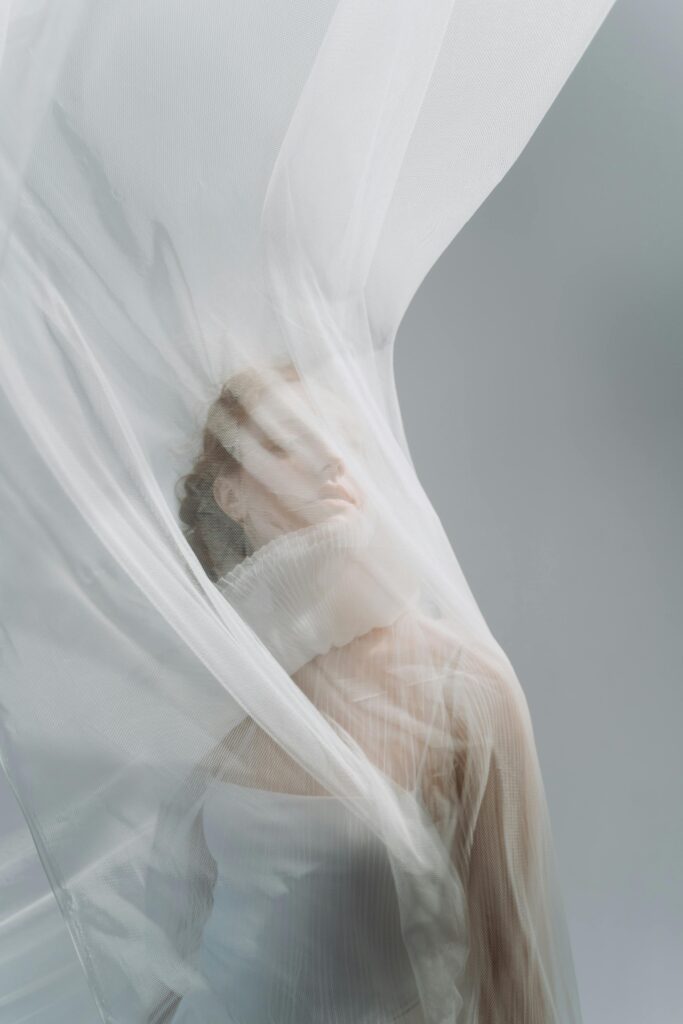 More Than a Mood: The Real Science of Dopamine Dressing 3 Hands touching contrasting fabrics: a soft, cozy sweater and a crisp, structured shirt, illustrating texture and silhouette in dopamine dressing.