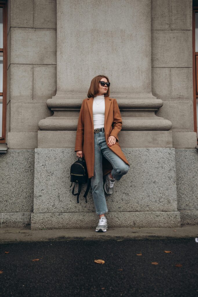 Close-up of a layered outfit demonstrating staggered hemlines and a defined waist, illustrating how to manage proportions when you layer clothes without bulk.