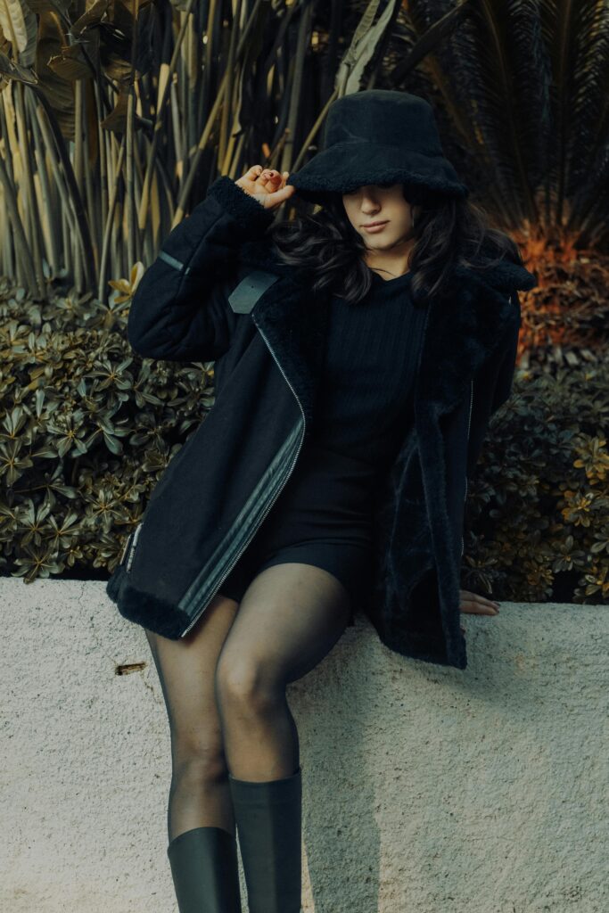Woman quickly putting on a tailored blazer over a core simple dress, showing a change in silhouette.