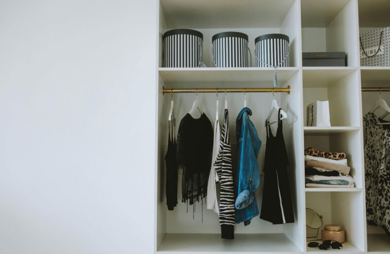 Wardrobe decluttering with neutral clothing laid out intentionally