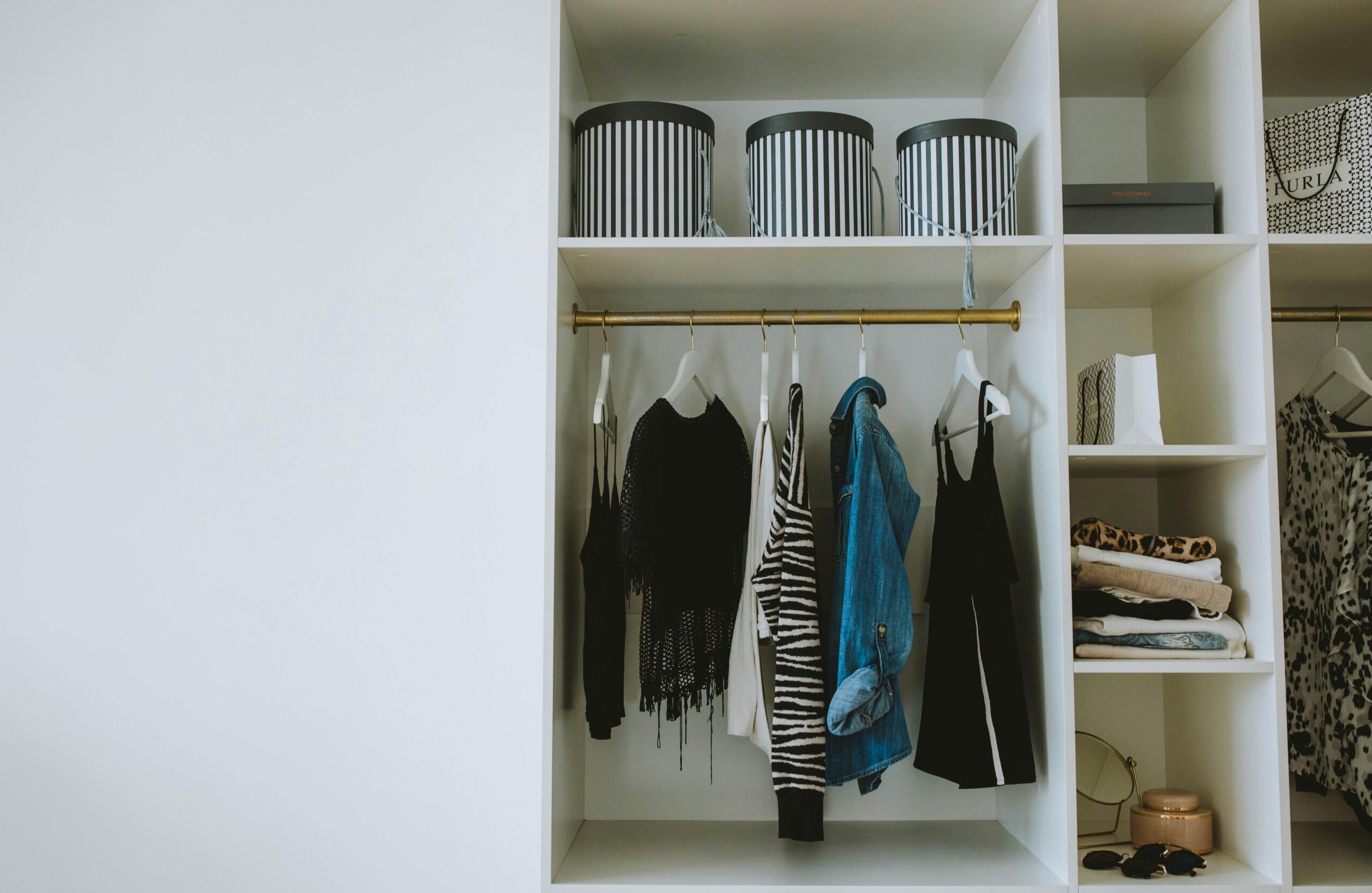 Wardrobe decluttering with neutral clothing laid out intentionally